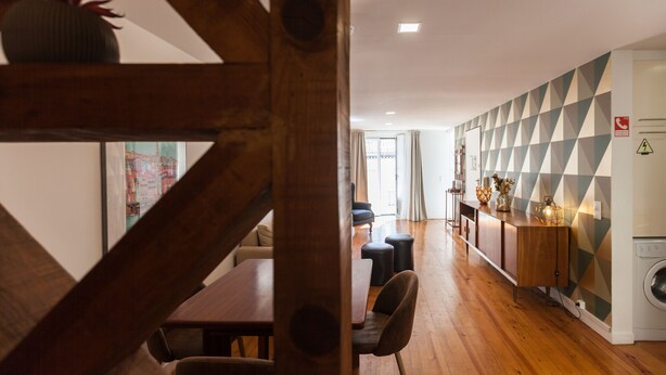 A modern kitchen with wooden cabinets, a built-in oven, and a countertop with decorative items. - FLH Castle Duplex with Terrace (Lisbon)