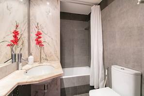 Bathtub, hair dryer, towels, shampoo