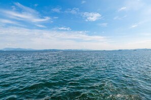 A view of a large body of water with distant landforms under a clear sky.