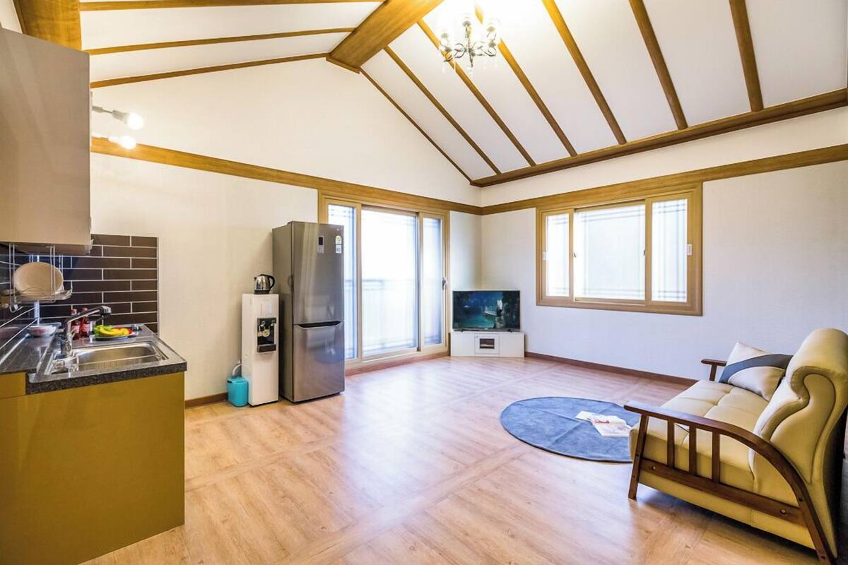 A spacious living area with a kitchen, a dining table, and a sofa.