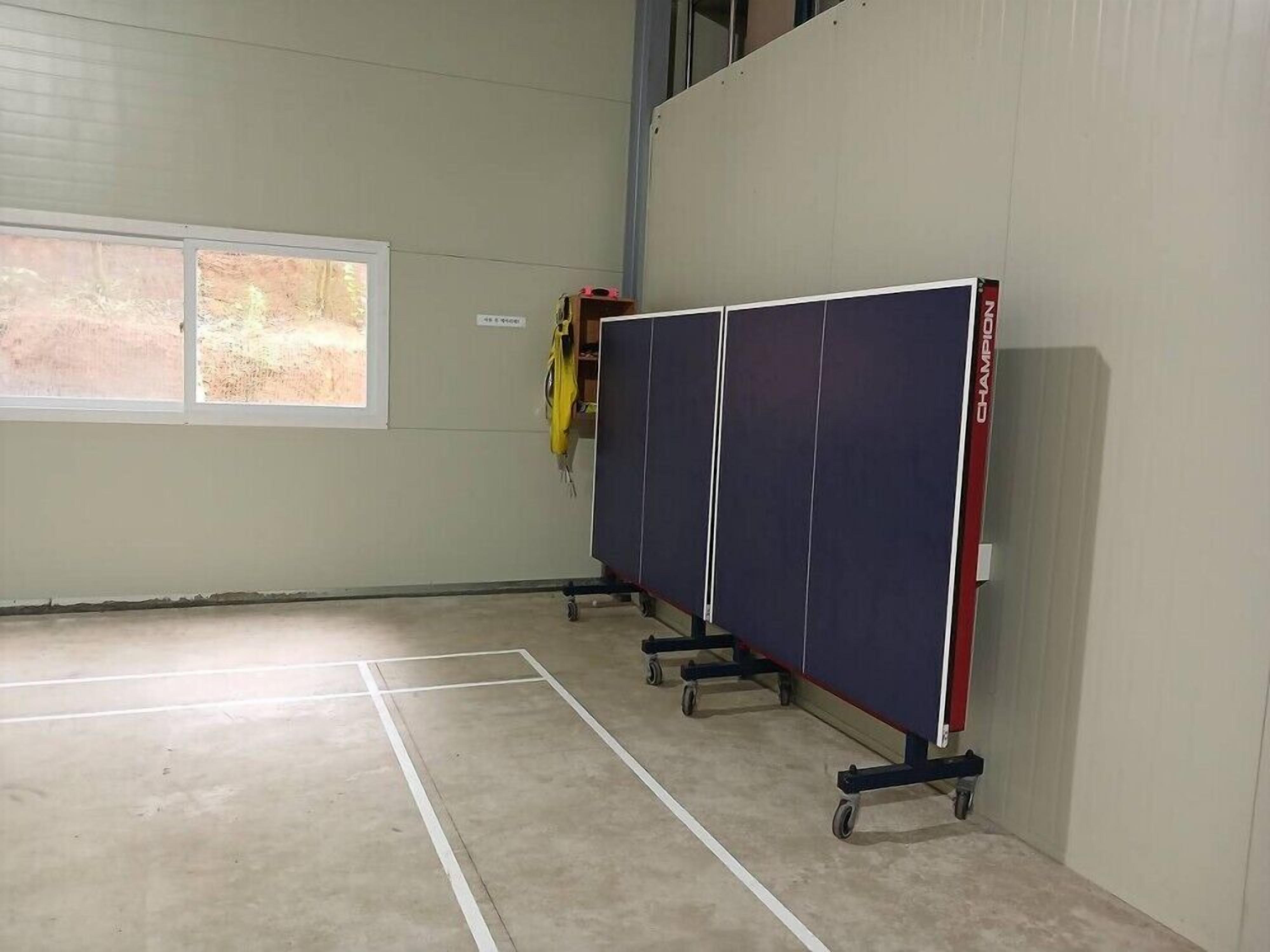 A room with a large window, a door, and a wall-mounted cabinet.