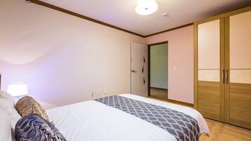 A bedroom with a bed, a wardrobe, and a door.