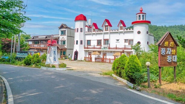 Un edificio con aspecto de castillo, con varias torres y un cartel.