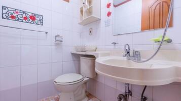 A bathroom with a toilet, sink, and mirror.