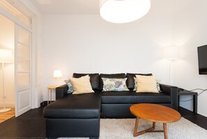 Una sala de estar moderna con un sofá modular, una mesita de centro y una lámpara.