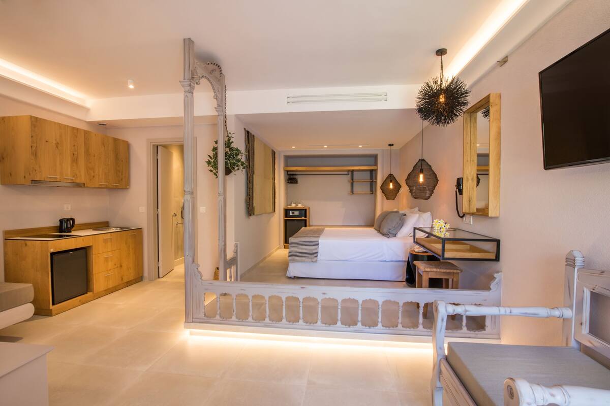 A modern bedroom with a large bed, bedside tables, a wardrobe, and a television.