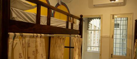A room with a bunk bed, a window with a view, and a ceiling fan.