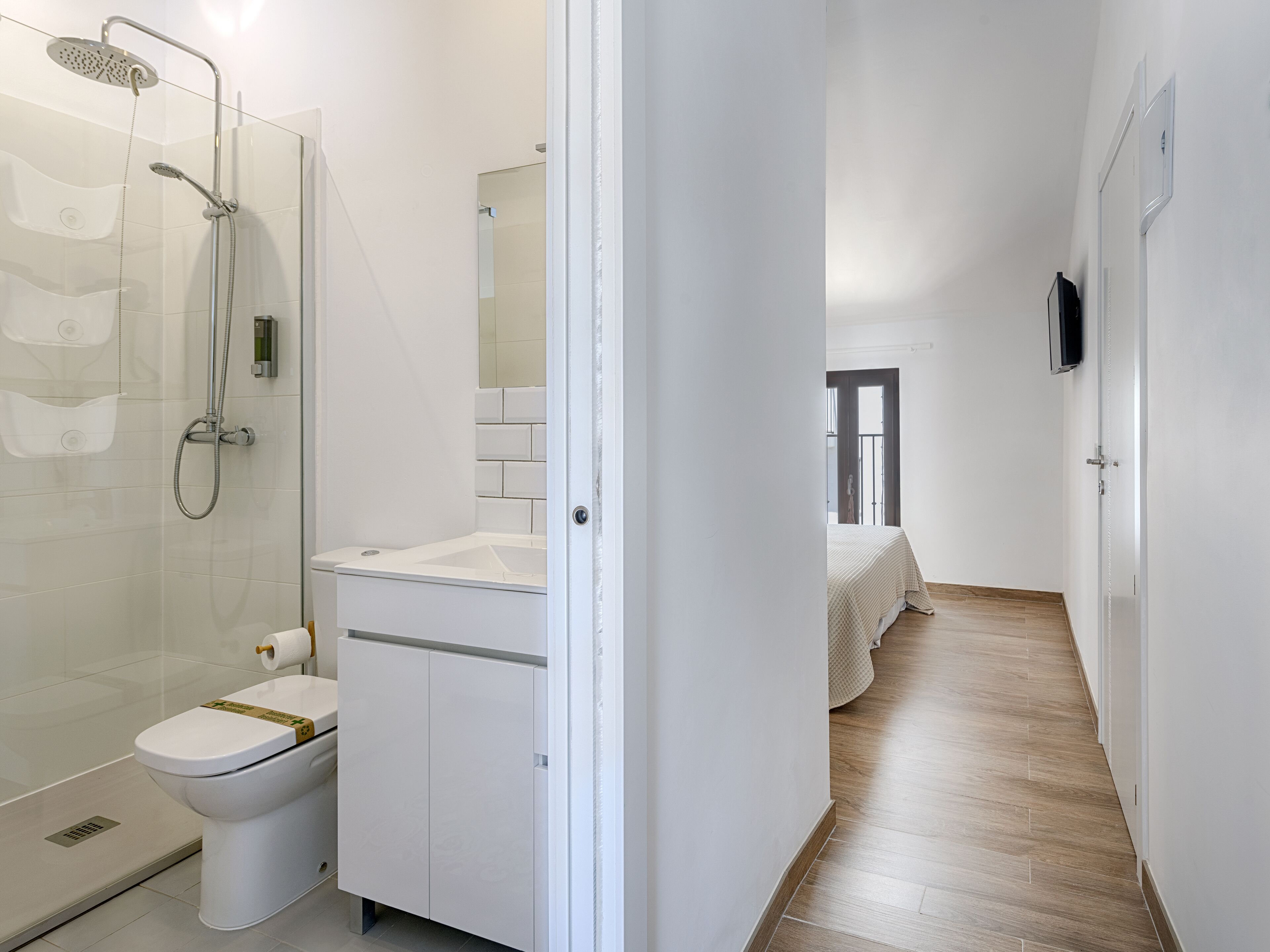 A modern bathroom with a shower, toilet, and sink.