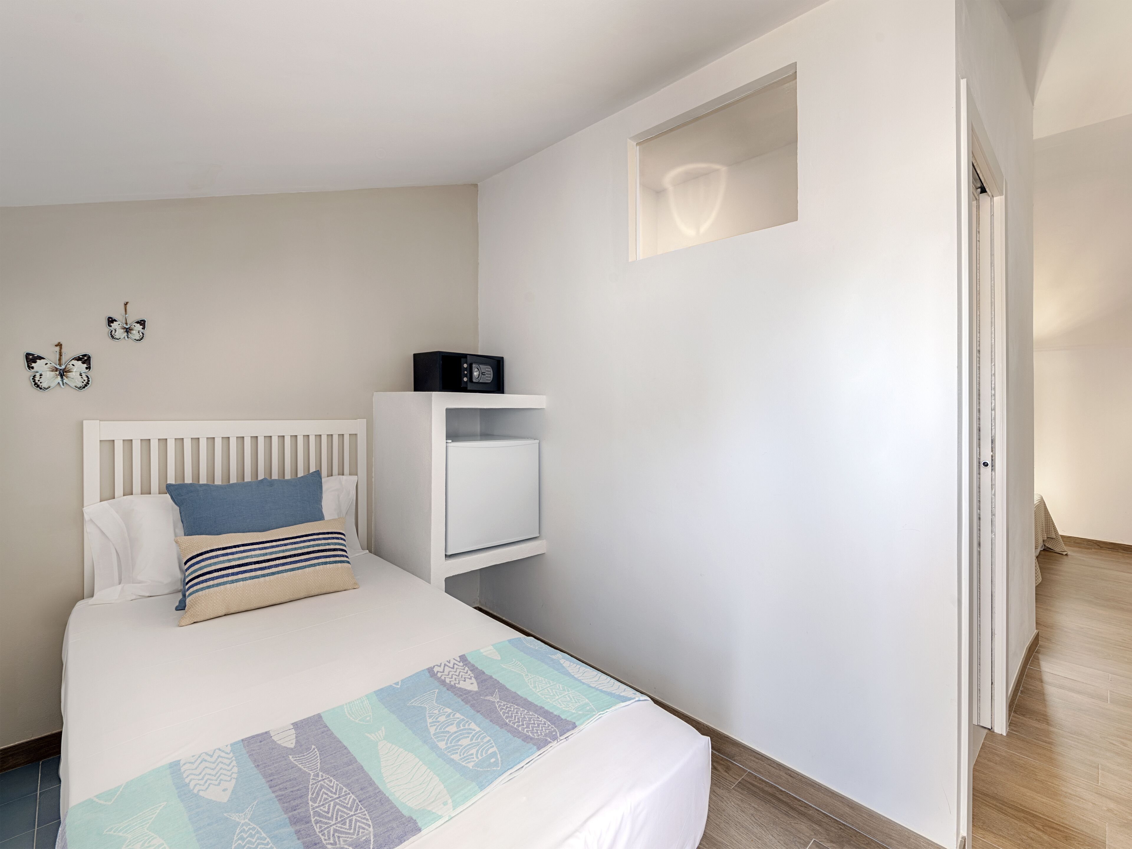 Ein Schlafzimmer mit Bett, Nachttisch und einem kleinen Regal.