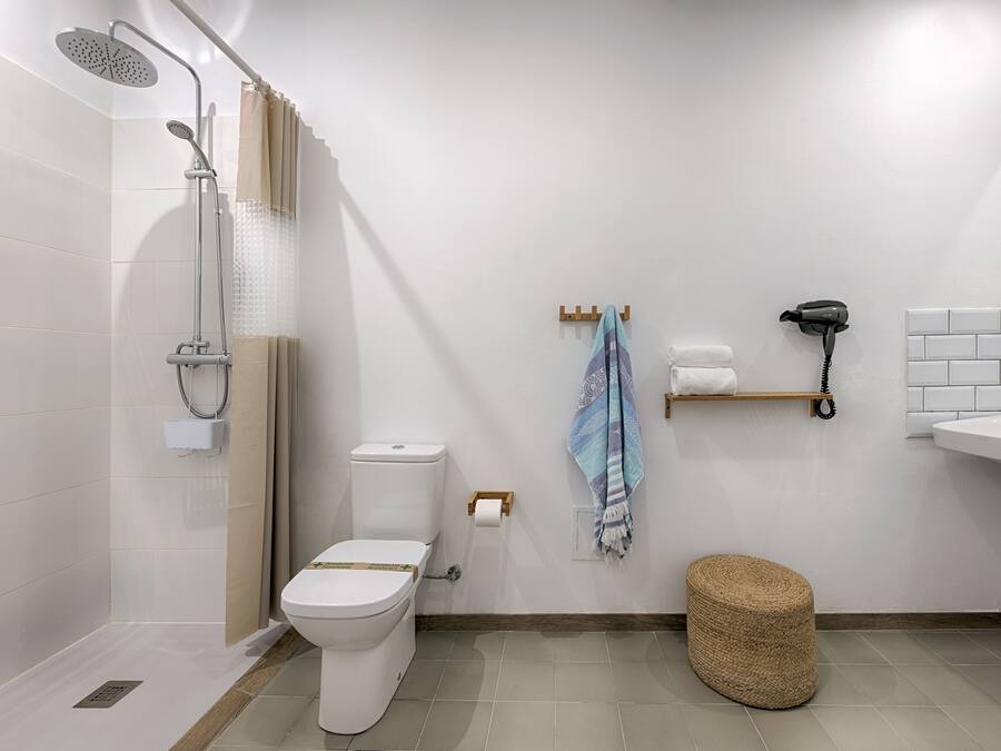 Un bany modern amb dutxa, vàter i una barra de tovalloles.