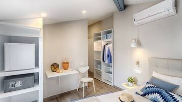 Habitación de hotel moderna con cama, mesita de noche, armario y escritorio con silla.