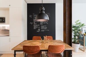 Enjoy meals in this dining area with a wooden table and four chairs, a microwave, and a chalkboard wall.