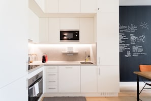 Enjoy meals in the well-lit kitchen with a microwave, stainless steel sink, and chalkboard wall.