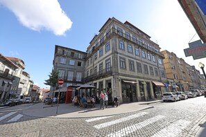 A historic building with multiple floors, a ground-level café, and a visible parking area.