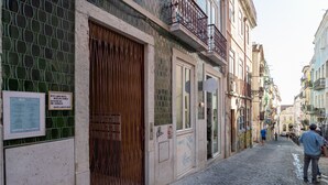 Eine enge Kopfsteinpflasterstraße, gesäumt von historischen Gebäuden, mit einem großen Holttor und einer Bank.