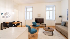 Un salon moderne comprenant un coin repas, un canapé et un téléviseur.
