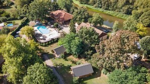 An aerial view of a residential area with a swimming pool, multiple houses, and a river. - Camping de l'Ill Colmar (Horbourg-Wihr)