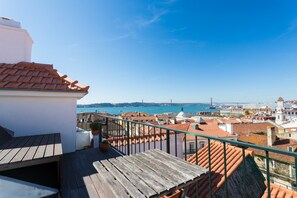 Une terrasse sur le toit offrant une vue sur la mer et un pont.