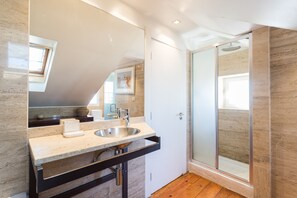 A modern bathroom with a large mirror, two sinks, and a glass shower enclosure. - FLH Chiado Skyline (Lisbon)