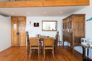 Un coin repas avec des meubles en bois, un grand miroir et un buffet.