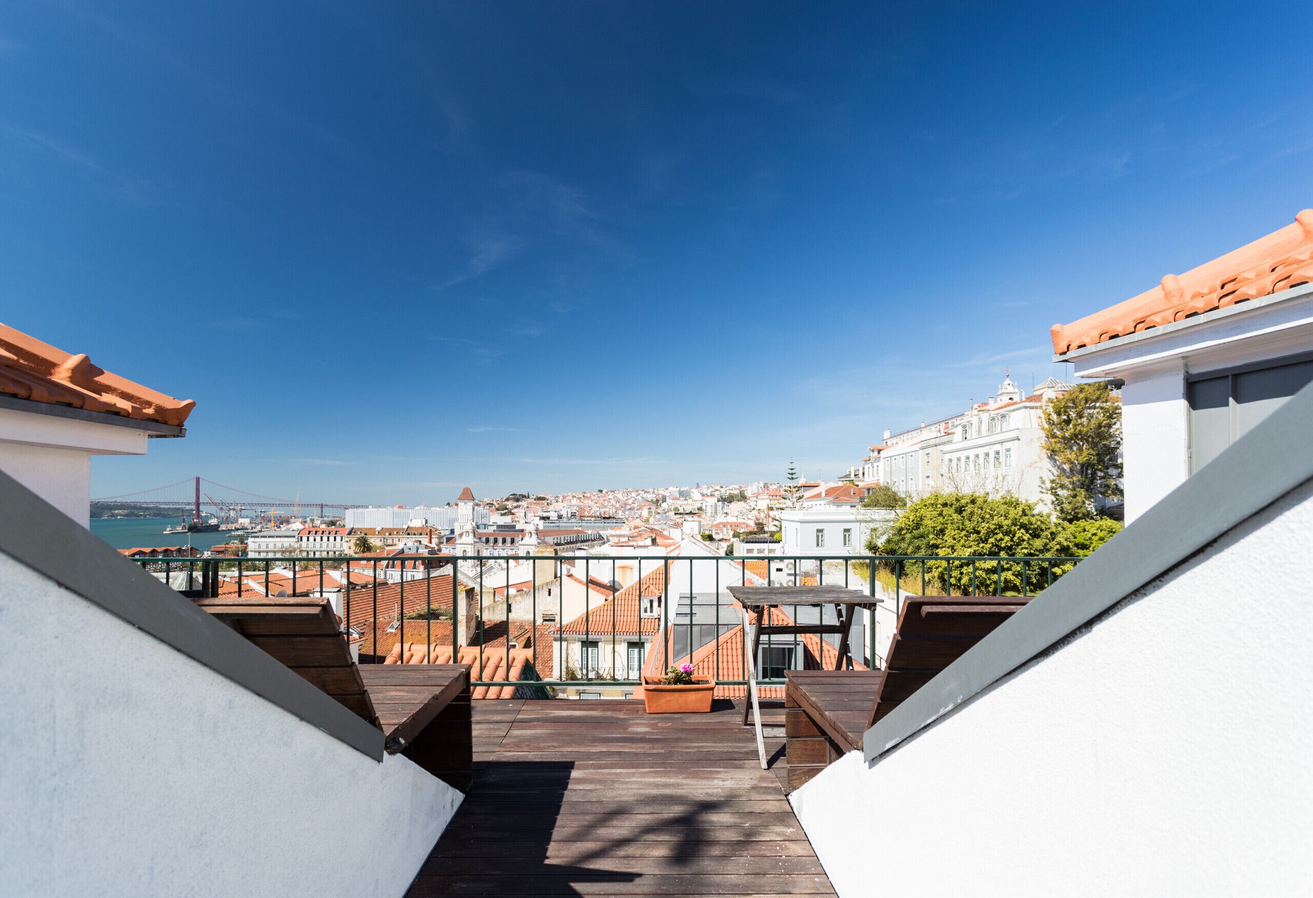 Una terraza en la azotea con vistas a la ciudad, incluyendo un puente y edificios.