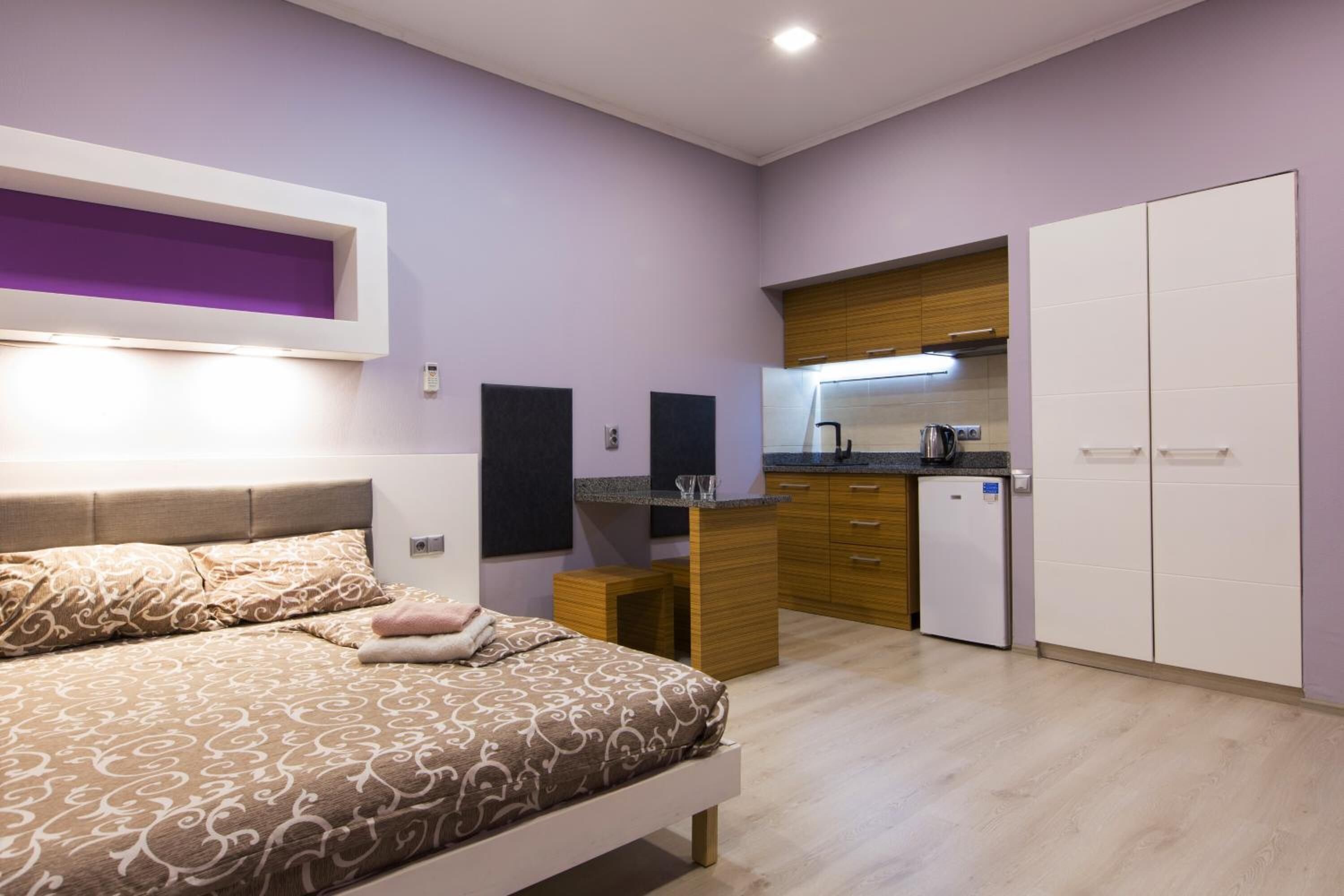 Een moderne slaapkamer met een bed, nachtkastjes en een inbouw-kast.