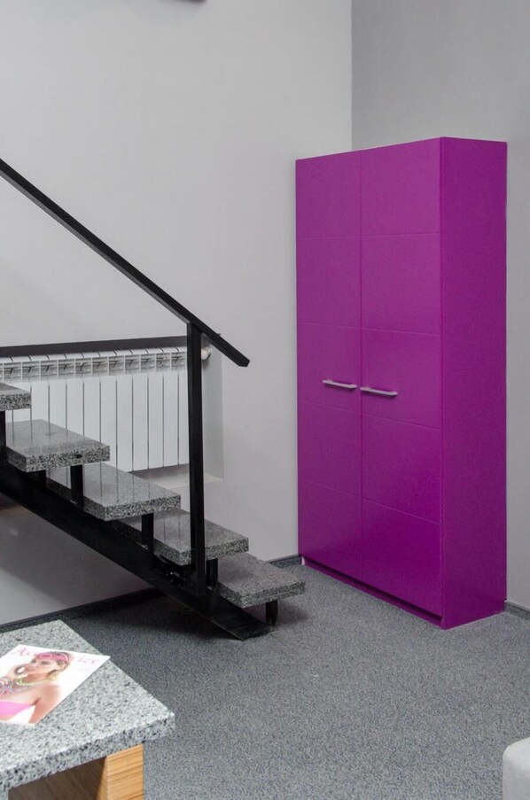 A staircase with a black handrail leading to a landing. - Pushkinskaya Apartments (Kharkiv)