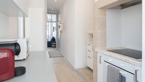 A modern kitchen with a built-in oven, a stovetop, and a microwave. - FLH Lx Factory Charming Place (Lisbon)