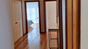 A hallway with wooden flooring, white walls, and a door leading to a room with a view. - Villa Blue Adriatic (Omis)