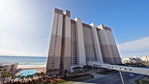 A tall hotel with multiple floors, a swimming pool, and a view of the beach. - Master on Gulf -Free round of Golf, Beach Chairs, & Activities Every Day! (Panama City Beach)