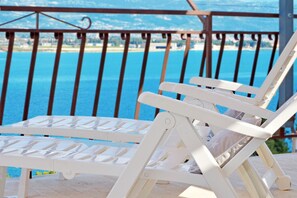Una silla lounge blanca con vistas al mar y a las montañas.