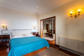 Een hotelkamer met een groot bed, nachtkastjes, een bureau en een stoel.