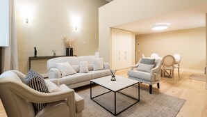 A modern living room with a sofa, armchairs, a coffee table, and a cabinet.