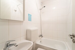 Een bad, een haardroger, handdoeken, shampoo