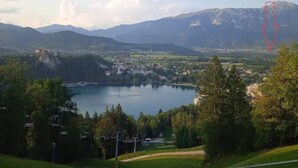 A mountainous landscape with a lake, a ski lift, and a village in the valley. - Apartment Mojca near Bled (Zabreznica)
