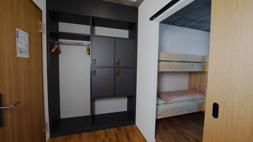 Habitación compacta con literas y un armario con varios compartimentos.