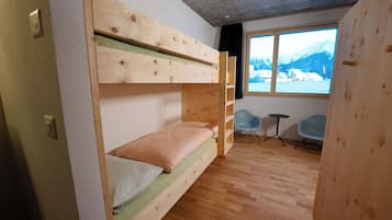 Ein Schlafzimmer mit Etagenbetten und Blick auf Berge durch ein großes Fenster.