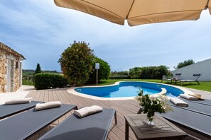 Una piscina con sillas de descanso y una pérgola.