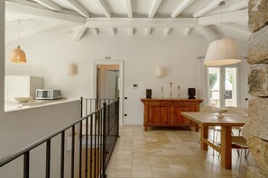Una cocina moderna con microondas, un mueble de madera y un comedor con mesa y sillas.