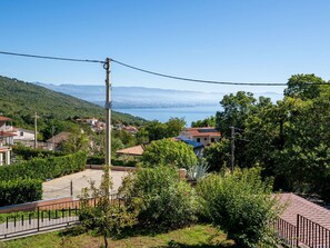 Ein Wohngebiet mit Häusern, blauem Himmel und einer entfernten Wasserlandschaft.