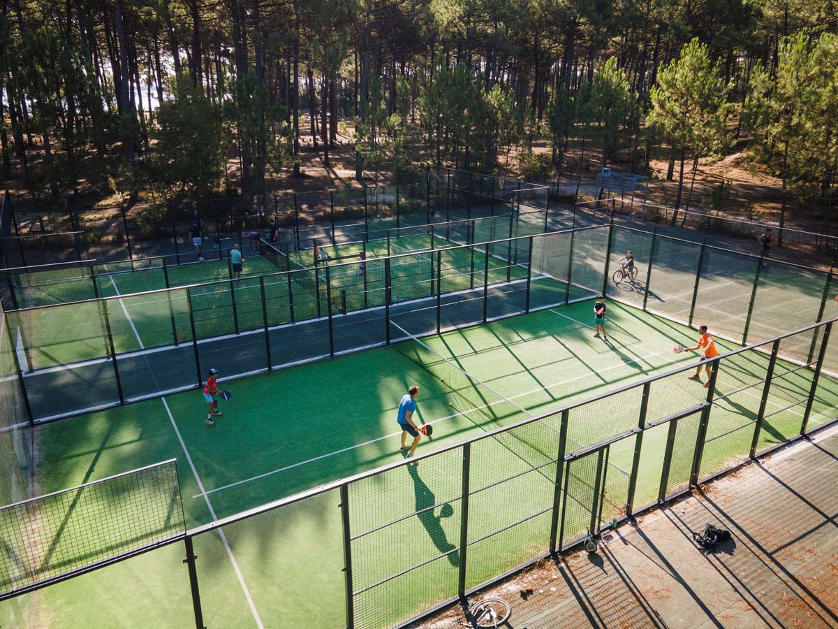 An outdoor tennis court surrounded by trees.