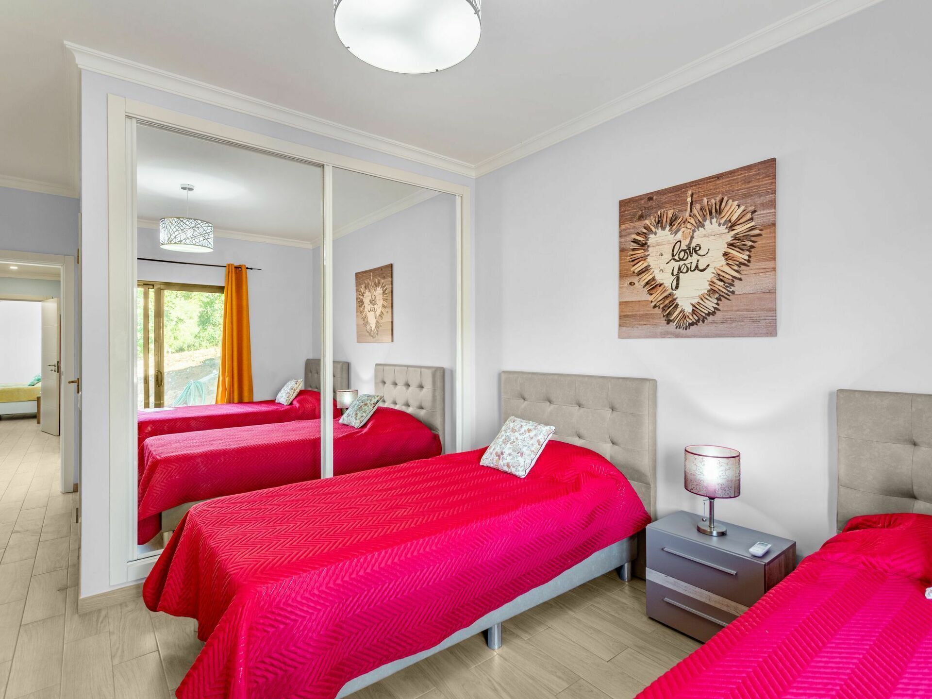 Ein Hotelzimmer mit zwei Betten, einem großen Spiegel und einer Wand mit einer Dekoration.