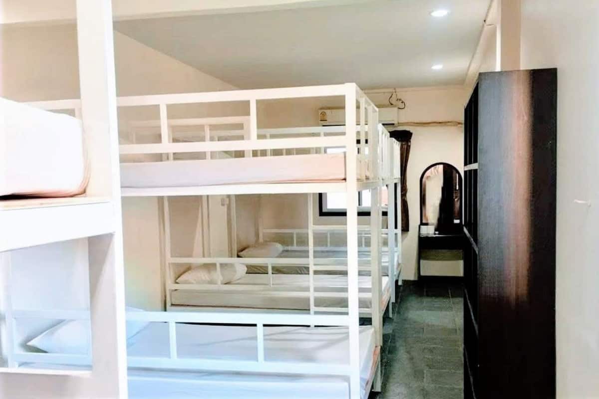A bunk bed room with a television and a dark-colored cabinet.