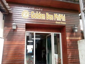 The exterior of Golden Bee Phi Phi Guest House with a wooden facade and a glass entrance. - Golden Bee PhiPhi Hostel (Ko Phi Phi)