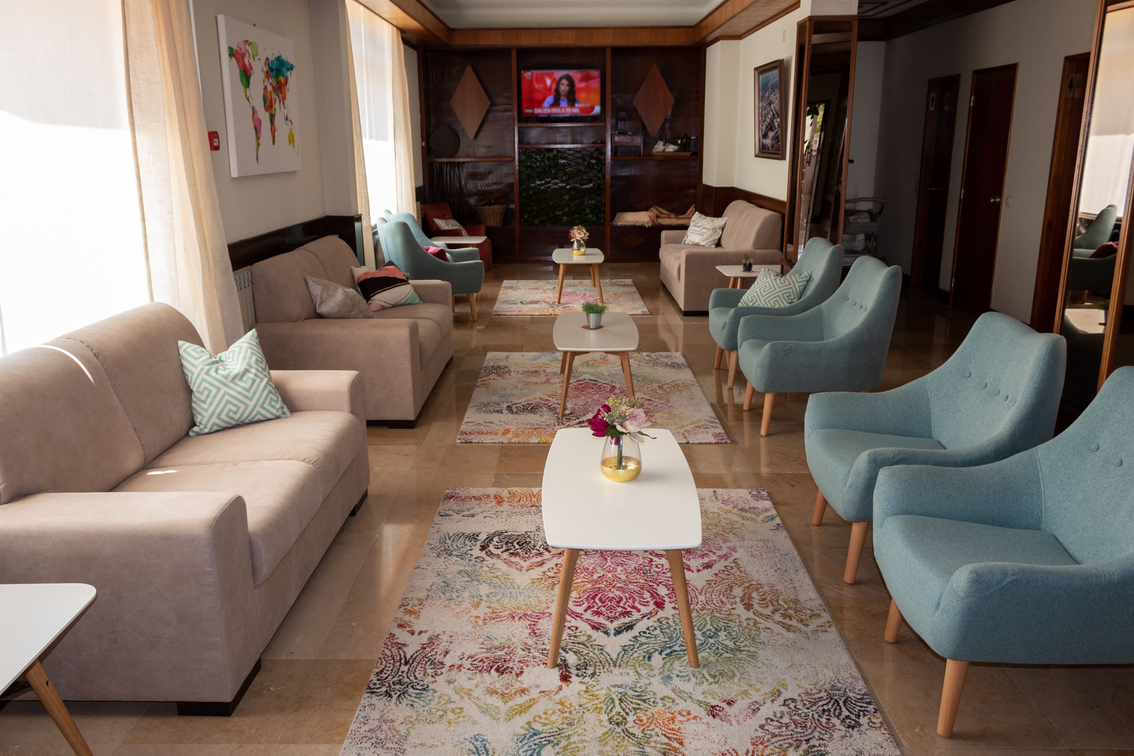 Una sala de estar moderna con un sofá, sillones, una mesita de centro y un televisor.