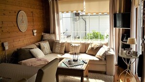 En hyggelig stue med sofa, sofabord og fjernsyn.