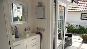 Et badeværelse med hvid kommode, spejl og bruseområde.