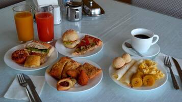Una tavola imbandita con piatti, bevande e utensili per la colazione.