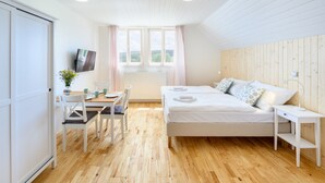 A modern room with a bed, a desk, and a TV. - Lipno Lake Chalet (Prední Výton)
