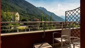 A balcony with a view of a mountain, a chair, and a table. - Lake Hotel La Pieve (Pisogne)